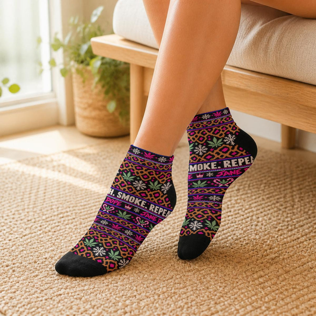 Angled on-foot view of Smoke Sleigh Repeat ankle socks, showing the leopard holiday print, lettering and black toe and heel panels.