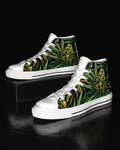 A pair of high-top sneakers with white rubber toe caps, laces, and soles, featuring a green tropical leaf and yellow flower print on the canvas uppers, displayed on a black reflective surface.