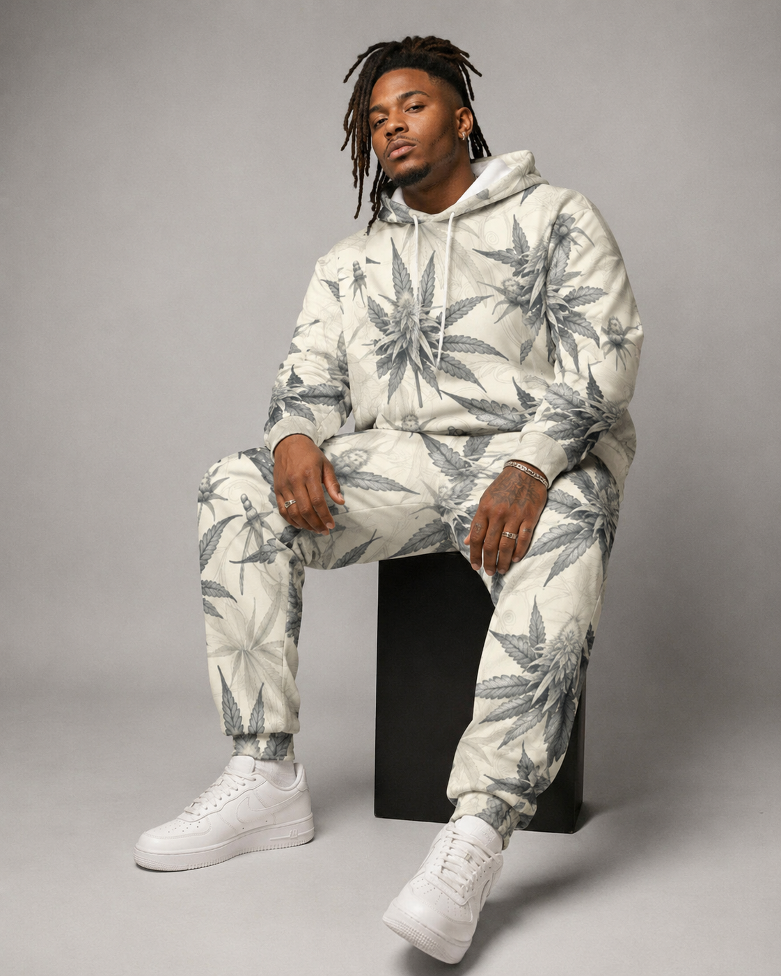 Green leaf print hoodie and sweatpants set, seated lifestyle shot on model
