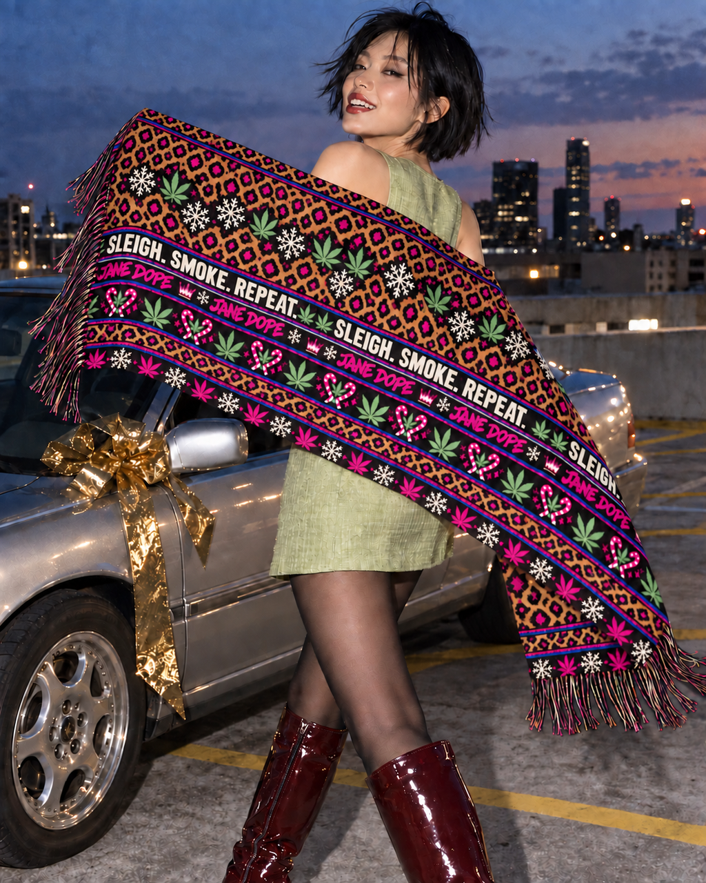 Sleigh. Smoke. Repeat Large Scarf held open beside a silver car at dusk, showing leopard spots, Herb motifs, snowflakes, lettering and fringed ends.