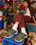 Bloom floral clogs with cream socks and burgundy tailoring in a flower shop