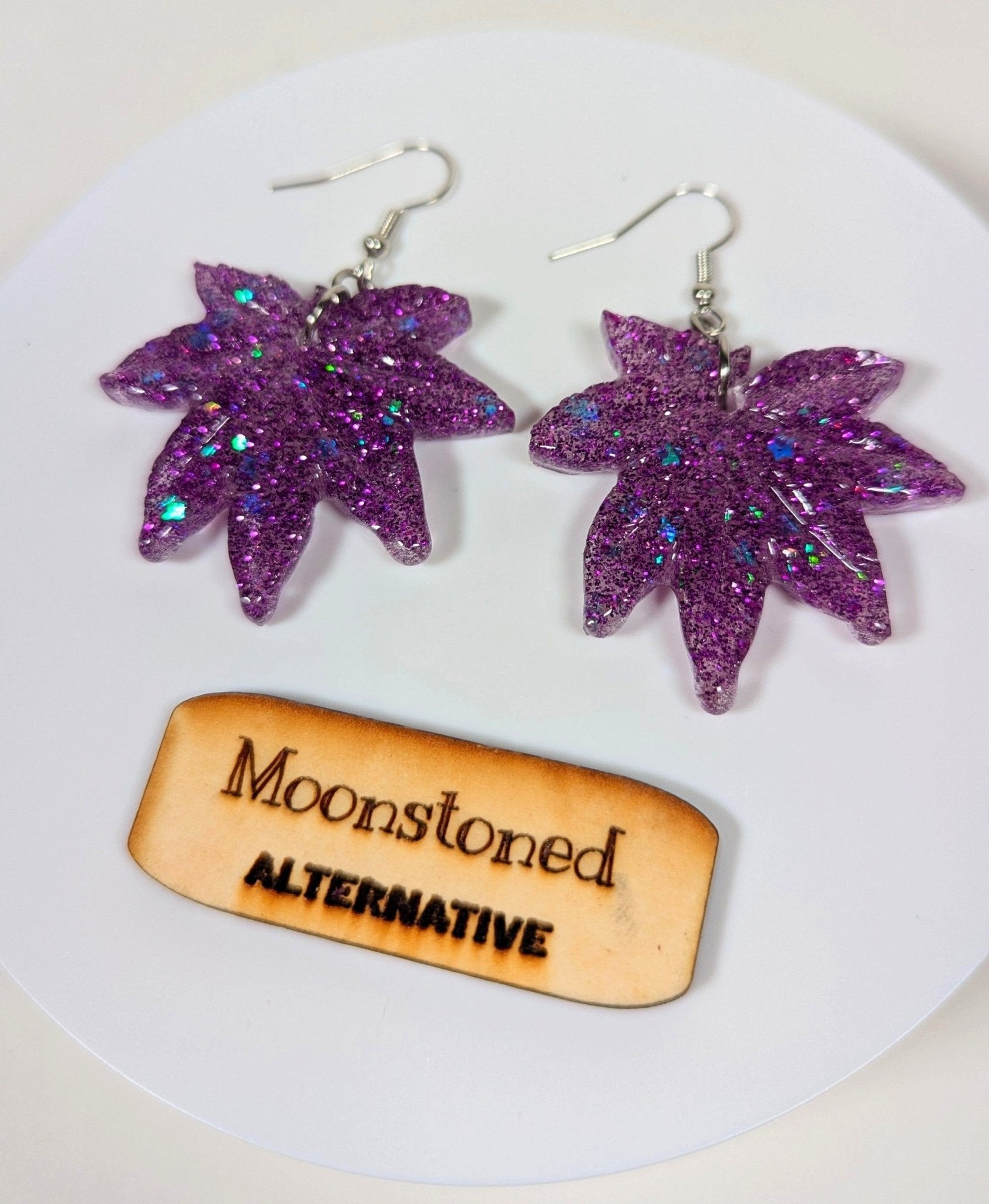 Glitter moonstone cannabis leaf earrings, size comparison shot