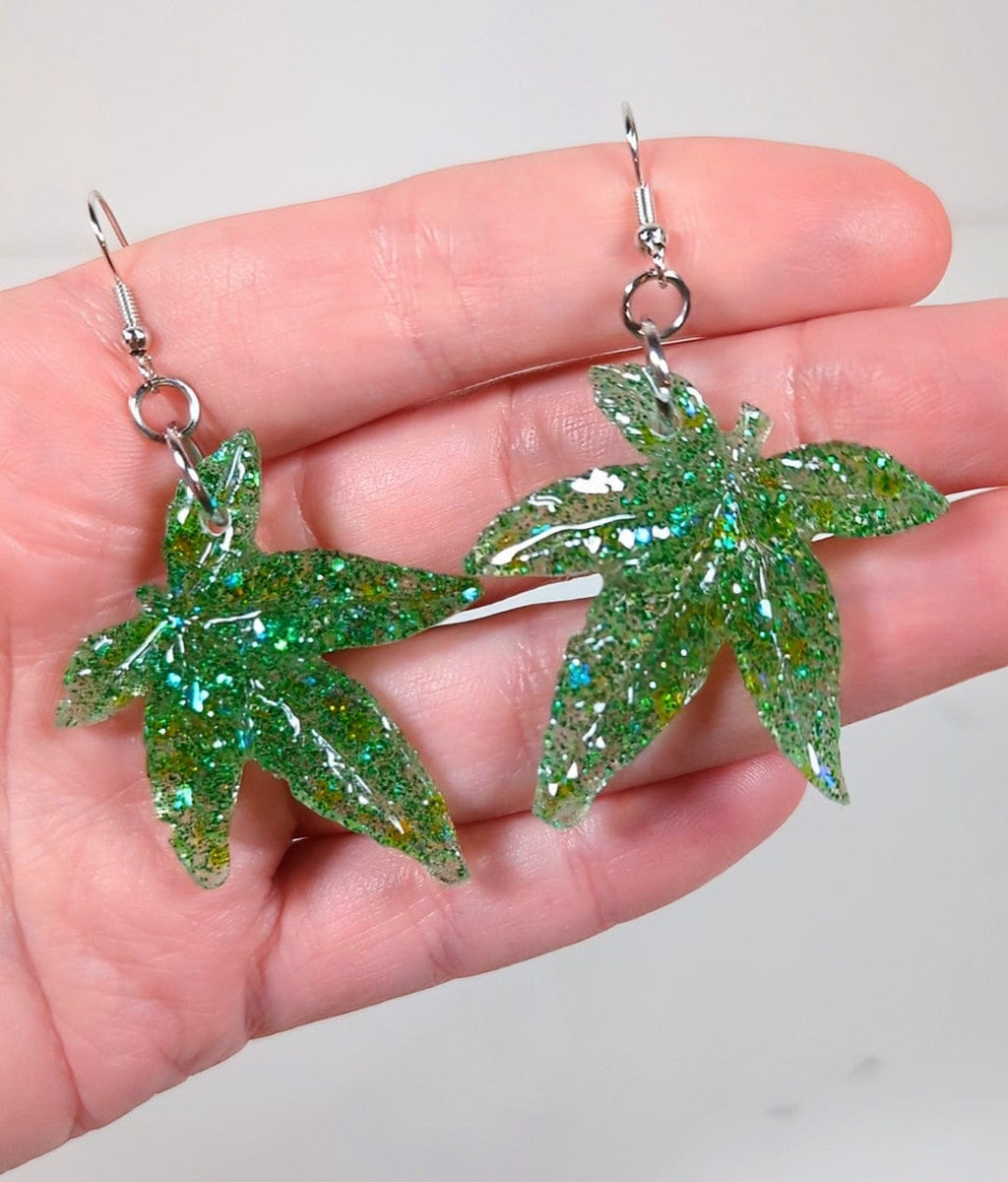 Glitter moonstone cannabis leaf earrings, styled on model