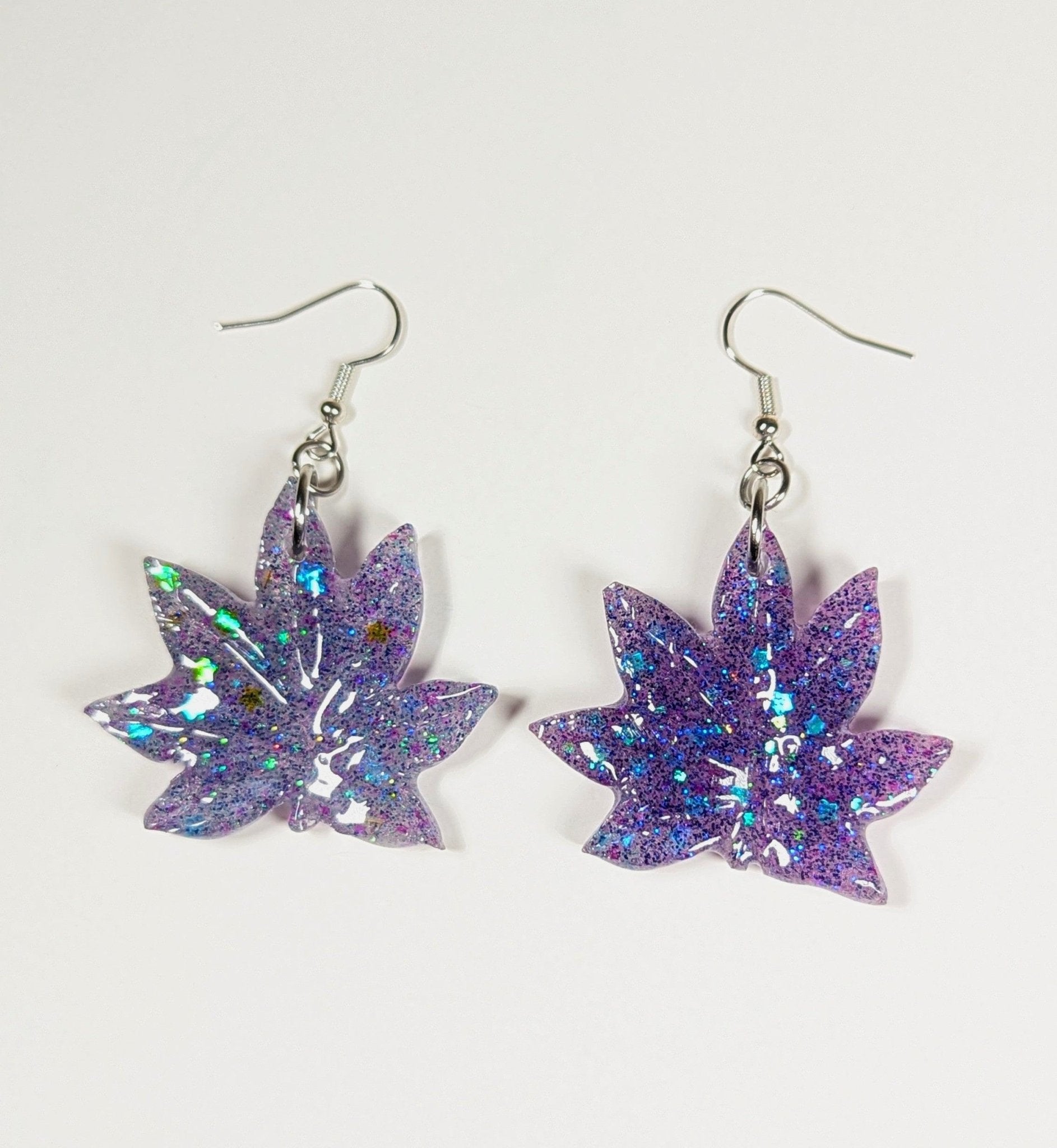 Glitter moonstone cannabis leaf earrings in blue, large sativa shape close-up