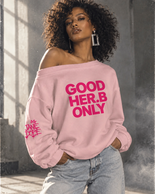 Model wearing pink GOOD HER.B ONLY off-shoulder sweatshirt with Jane Dope sleeve graphic