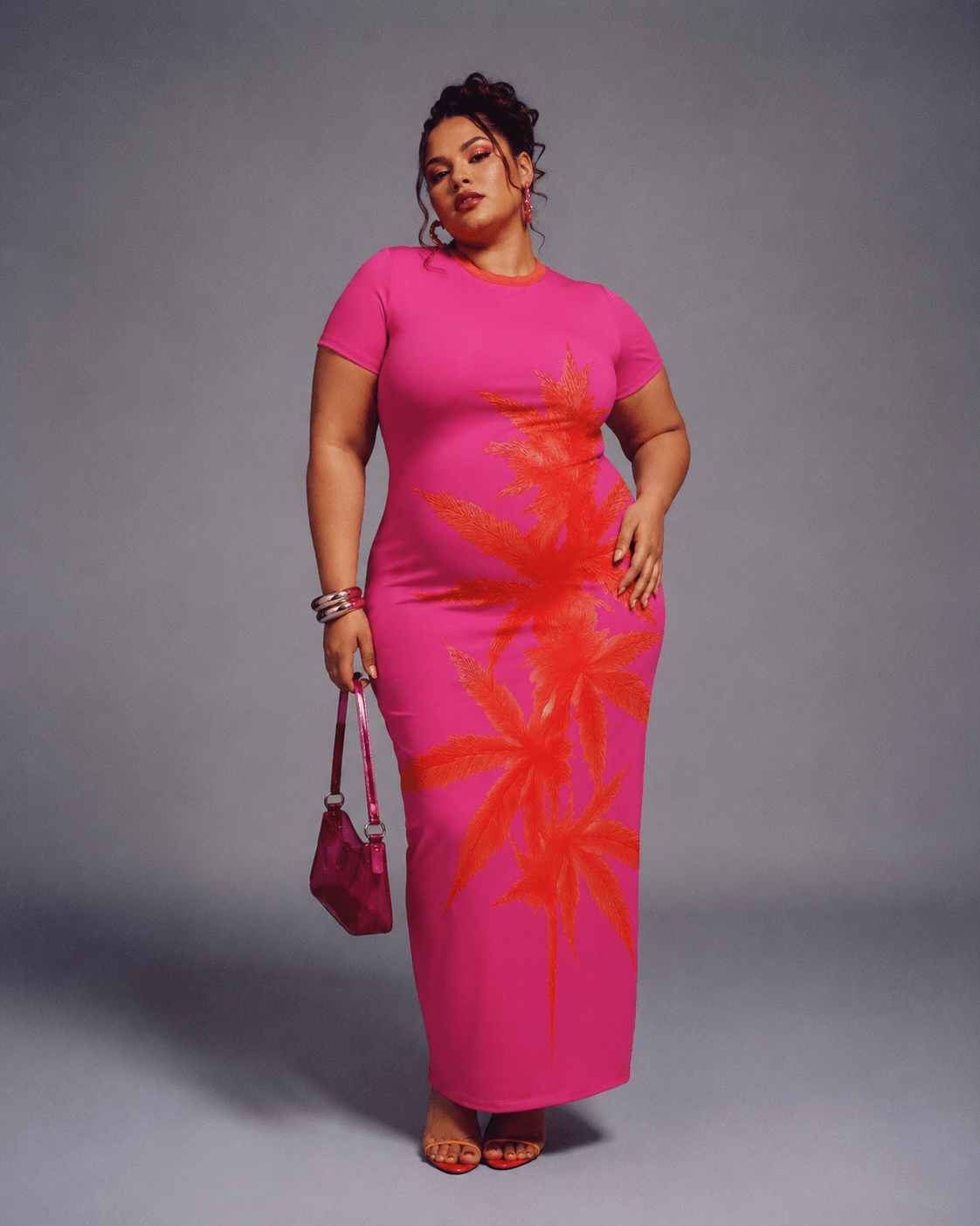 Pink tropical print bodycon dress, seated lifestyle shot on model