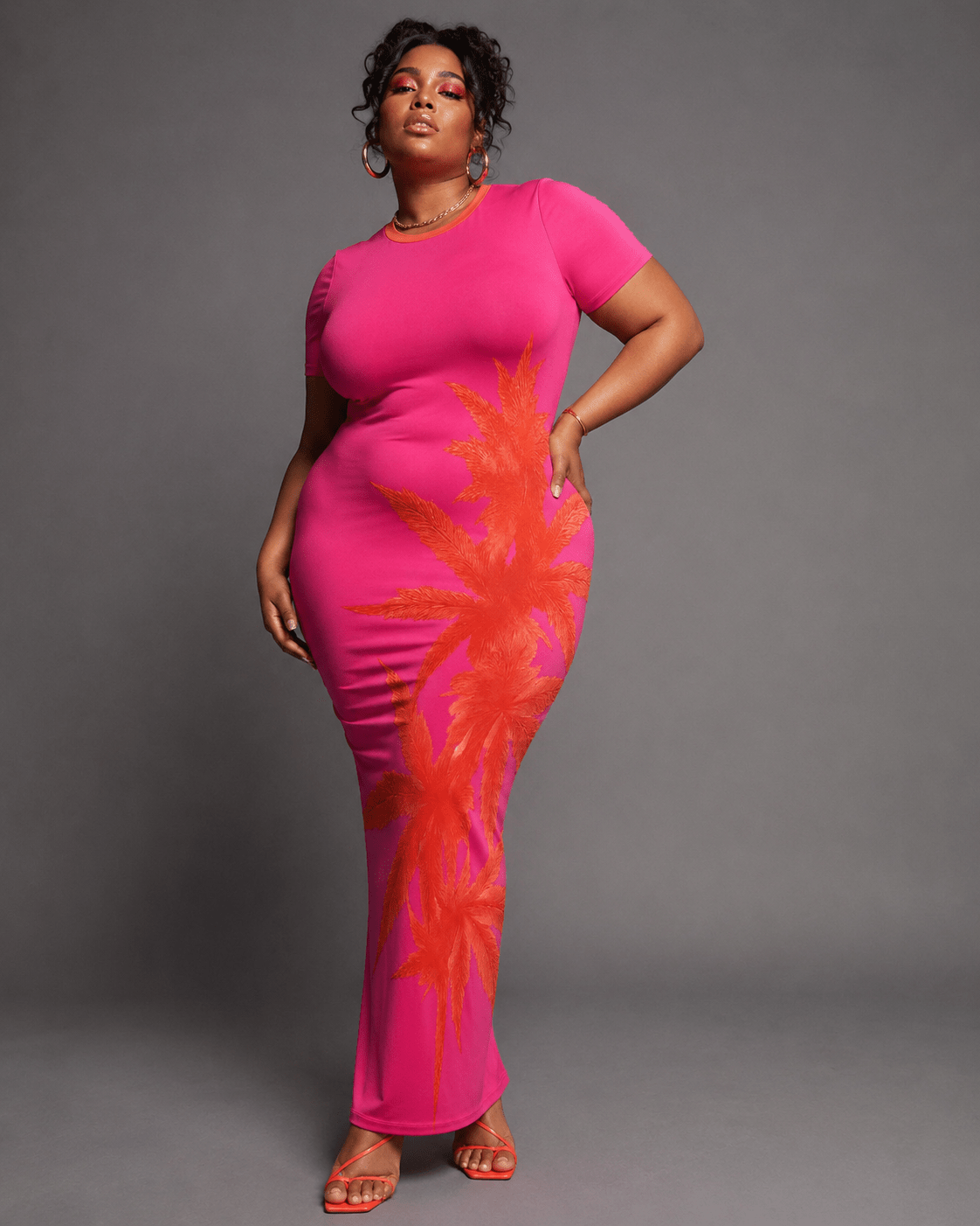 Pink tropical print bodycon dress, three-quarter view on model
