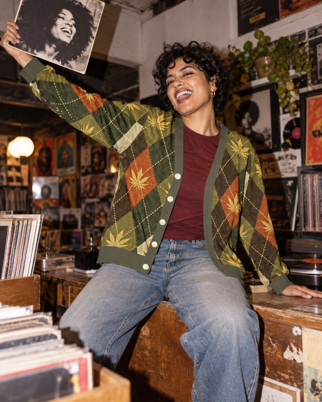 Argyle cardigan over a burgundy tee at a record-store counter