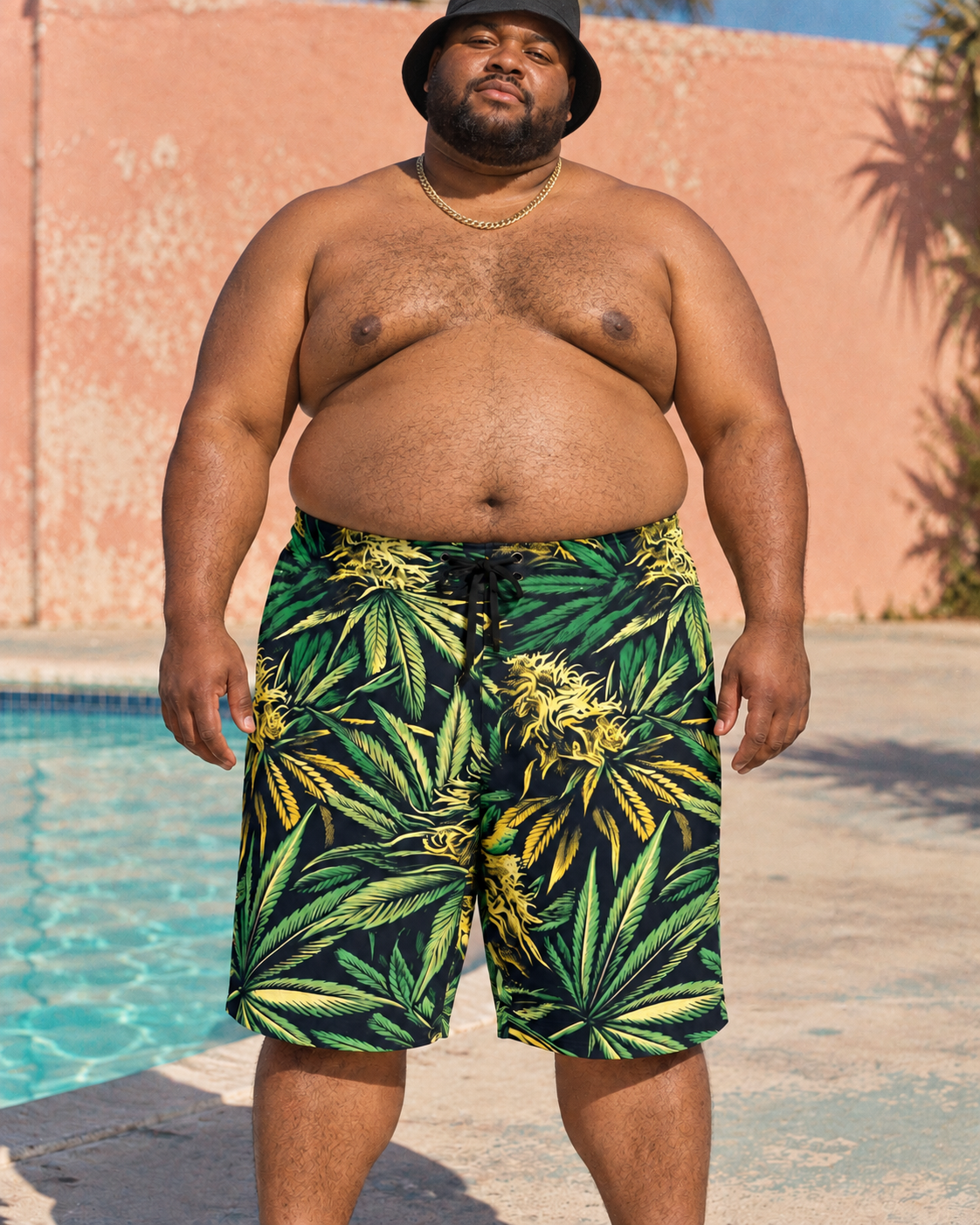 Big Buds men's green and yellow botanical board shorts styled with shirtless poolside look with black bucket hat.