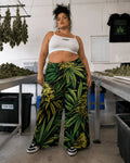 Front view of Big Buds wide-leg green and yellow print pants with a white crop top and black sneakers.
