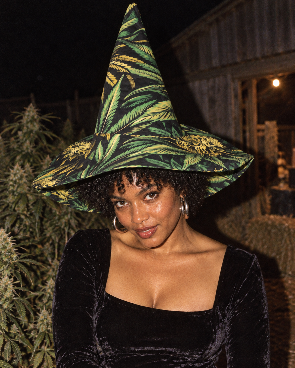 Big Buds green and yellow witch hat styled with black velvet in a grainy flash portrait.