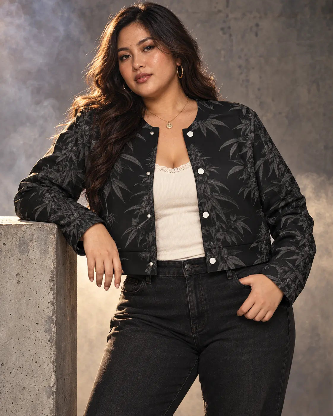 Black Widow cropped jacket styled with an ivory tank and black denim, beside a concrete plinth in a smoky studio.