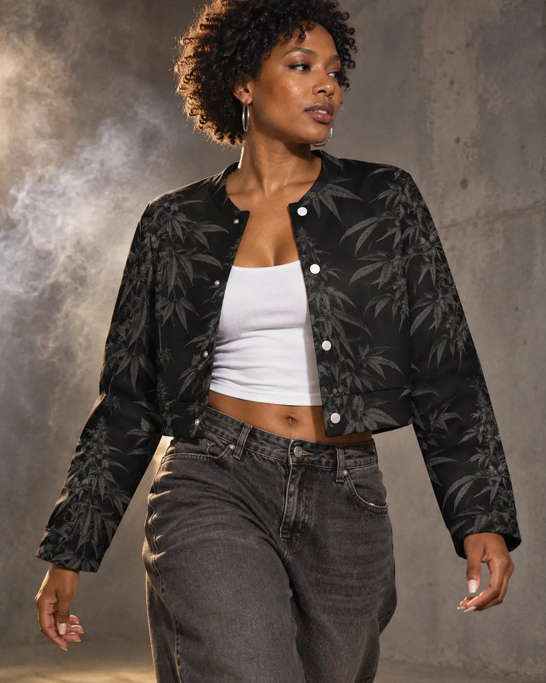 Black Widow cropped jacket styled open with a white tank and charcoal jeans, photographed mid-step in a gray studio.