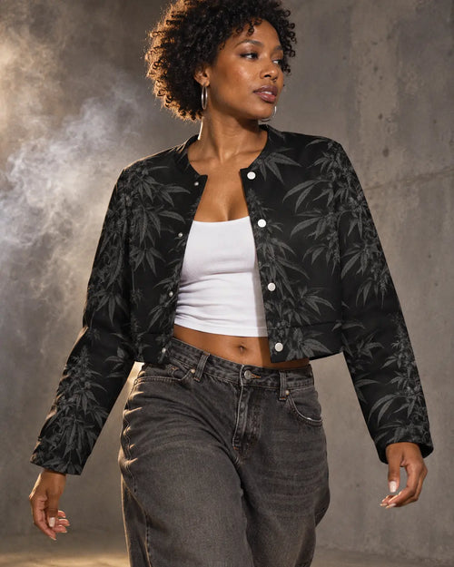 Black Widow cropped jacket styled open with a white tank and charcoal jeans, photographed mid-step in a gray studio.