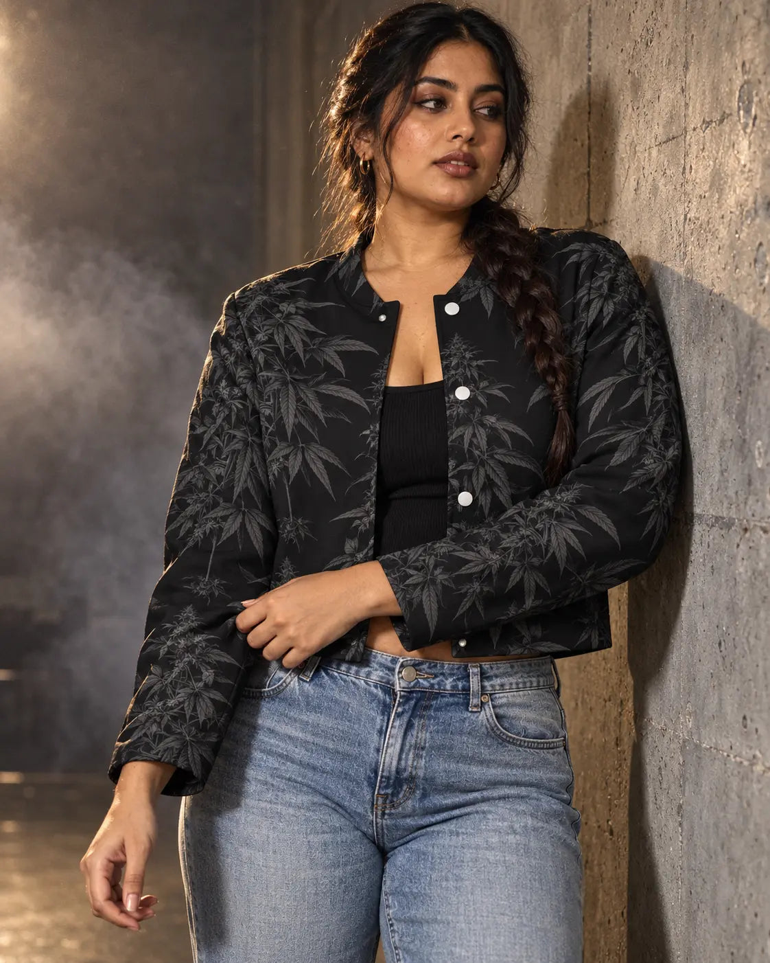 Three-quarter view of the Black Widow cropped jacket with tonal HER.B print, styled with a black tank and faded denim.