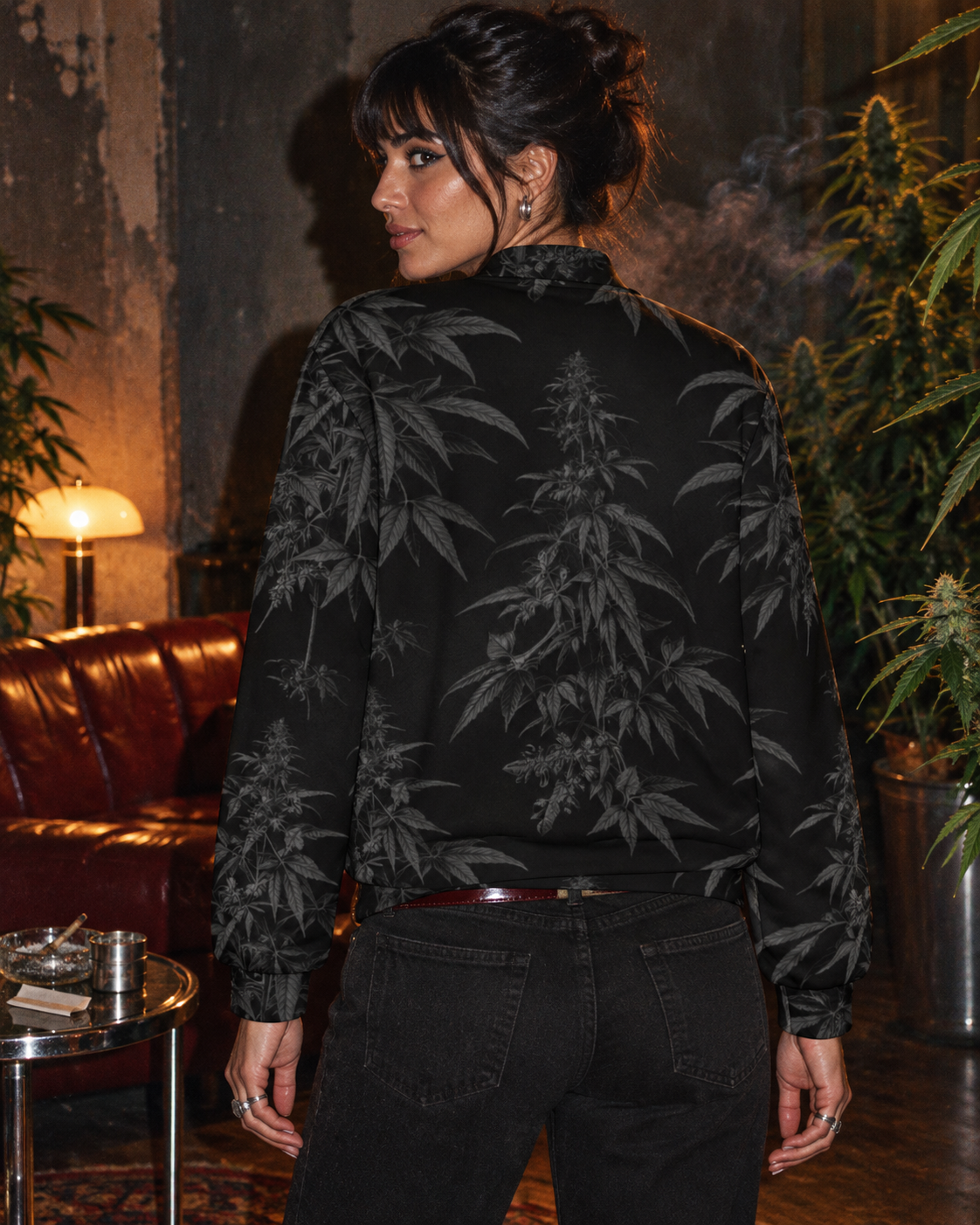Back of the Black Widow bomber jacket, showing charcoal flowering stems and leaves in a smoky lounge.