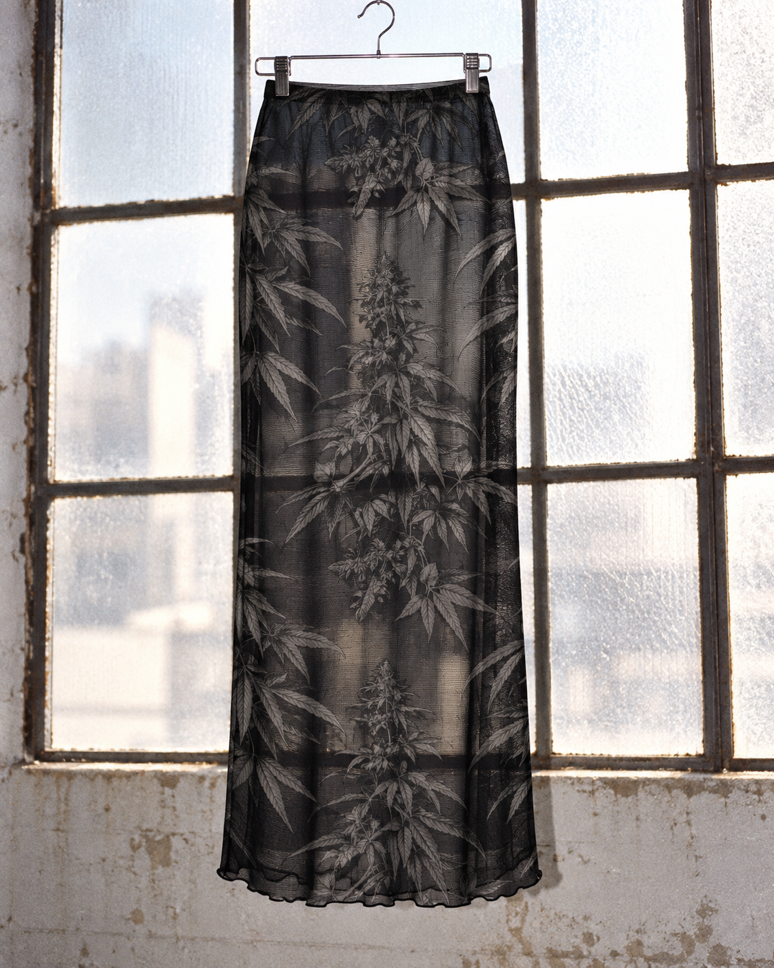 Black Widow unlined botanical mesh skirt backlit at a window to show the sheer fabric.