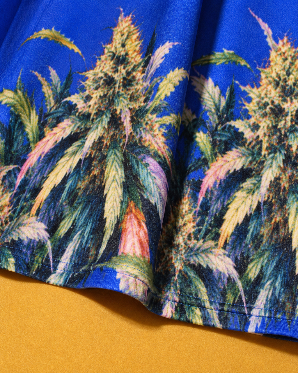 Close-up of the Blue Mazar botanical hem print and stitched edge on cobalt-blue fabric.