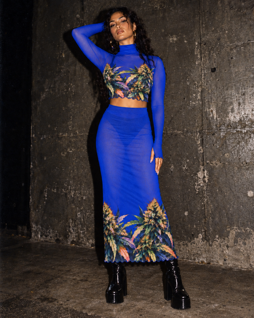 Blue Mazar sheer mesh high-neck top and midi skirt set against a dark concrete backdrop
