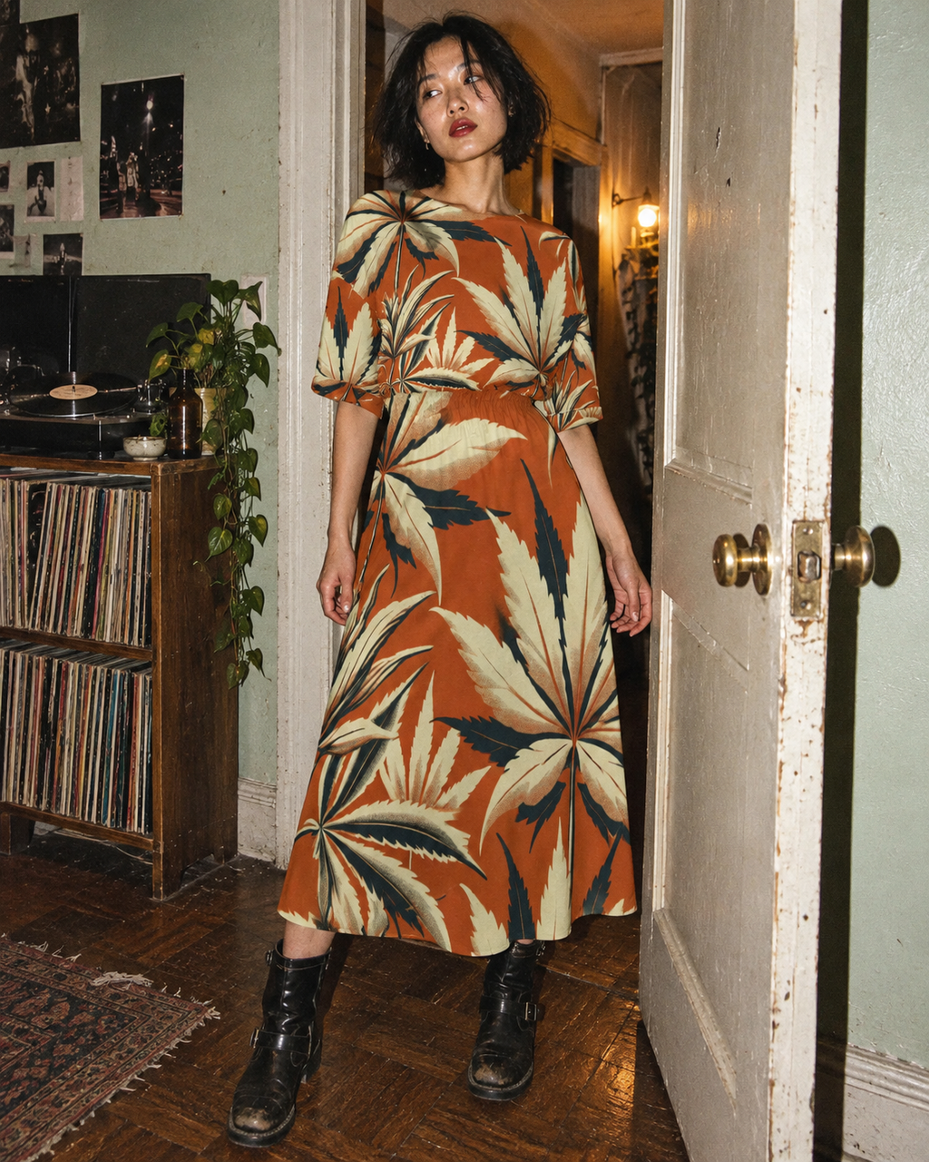 Jane Dope Cali Midi Pocket Dress in rust and cream leaf print, shown full length in an apartment doorway with black boots.