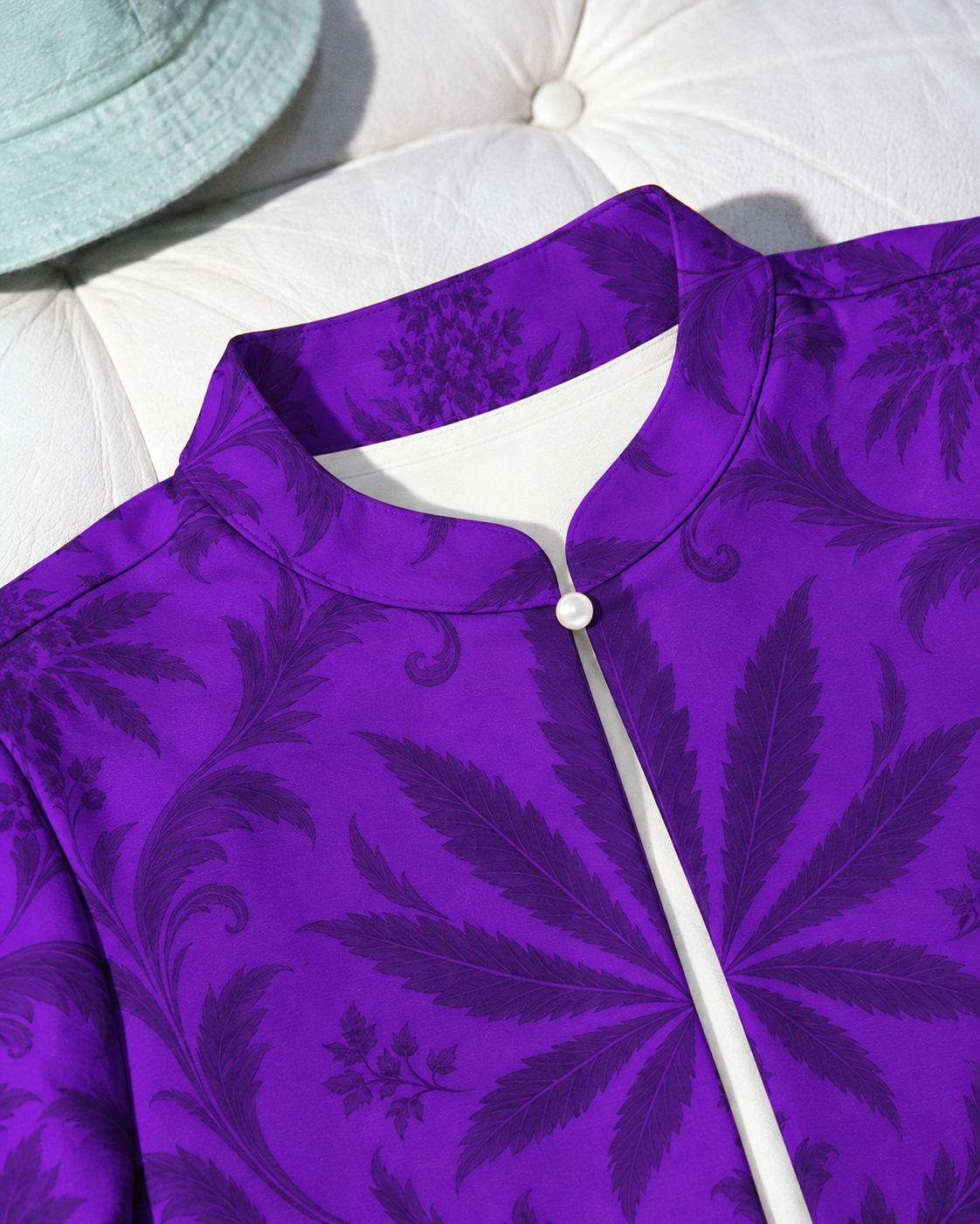 Close view of the Gelato bolero stand collar, single white round button and dark botanical print on violet fabric.