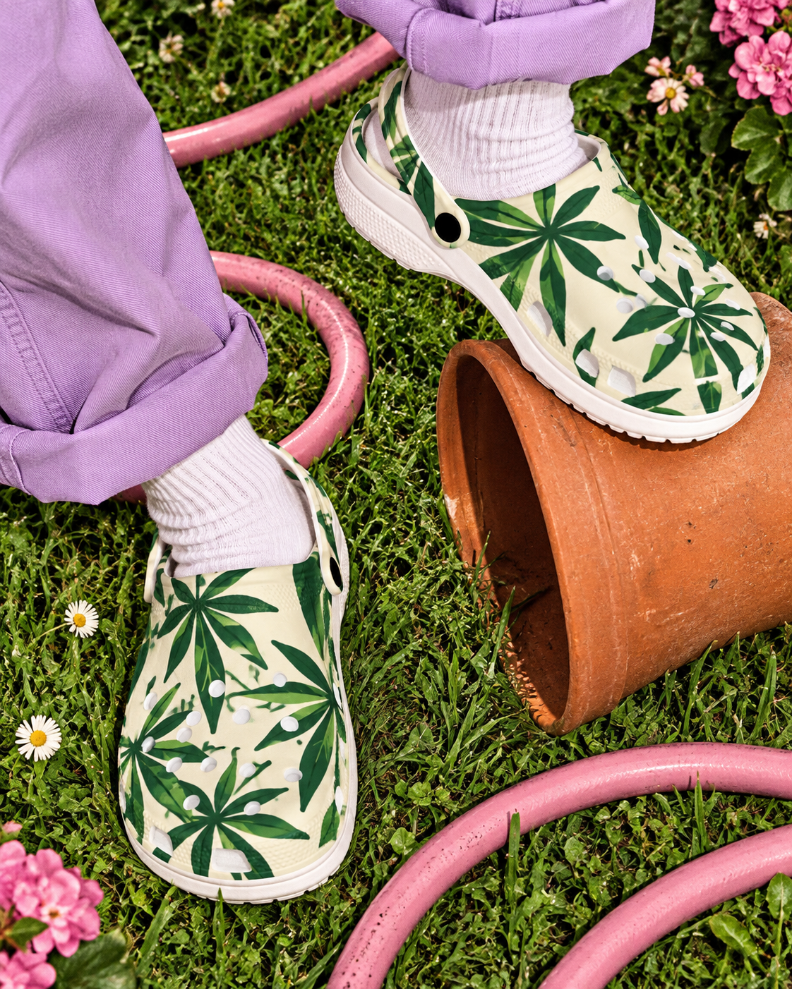 Grass Clogs editorial mockup with lilac trousers and white socks beside a terracotta pot and pink garden hose.