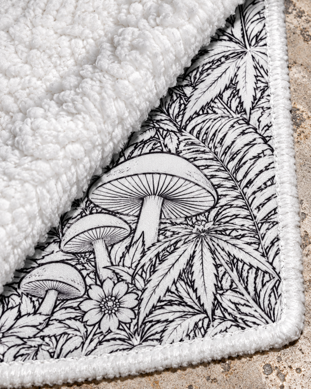 JD Magic blanket close-up showing the mushroom line art, stitched edge and plush white fleece backing