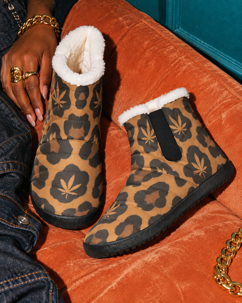 Leopard Booties on an apricot cushion, showing white plush lining, rounded toes and a black elastic side panel.