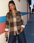 Lumber Jane brown plaid cotton shirt with Herb motifs, worn untucked with jeans beside a painted wall.