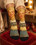 Monroe portrait socks with Jane Dope lettering and black toes on a red velvet stool