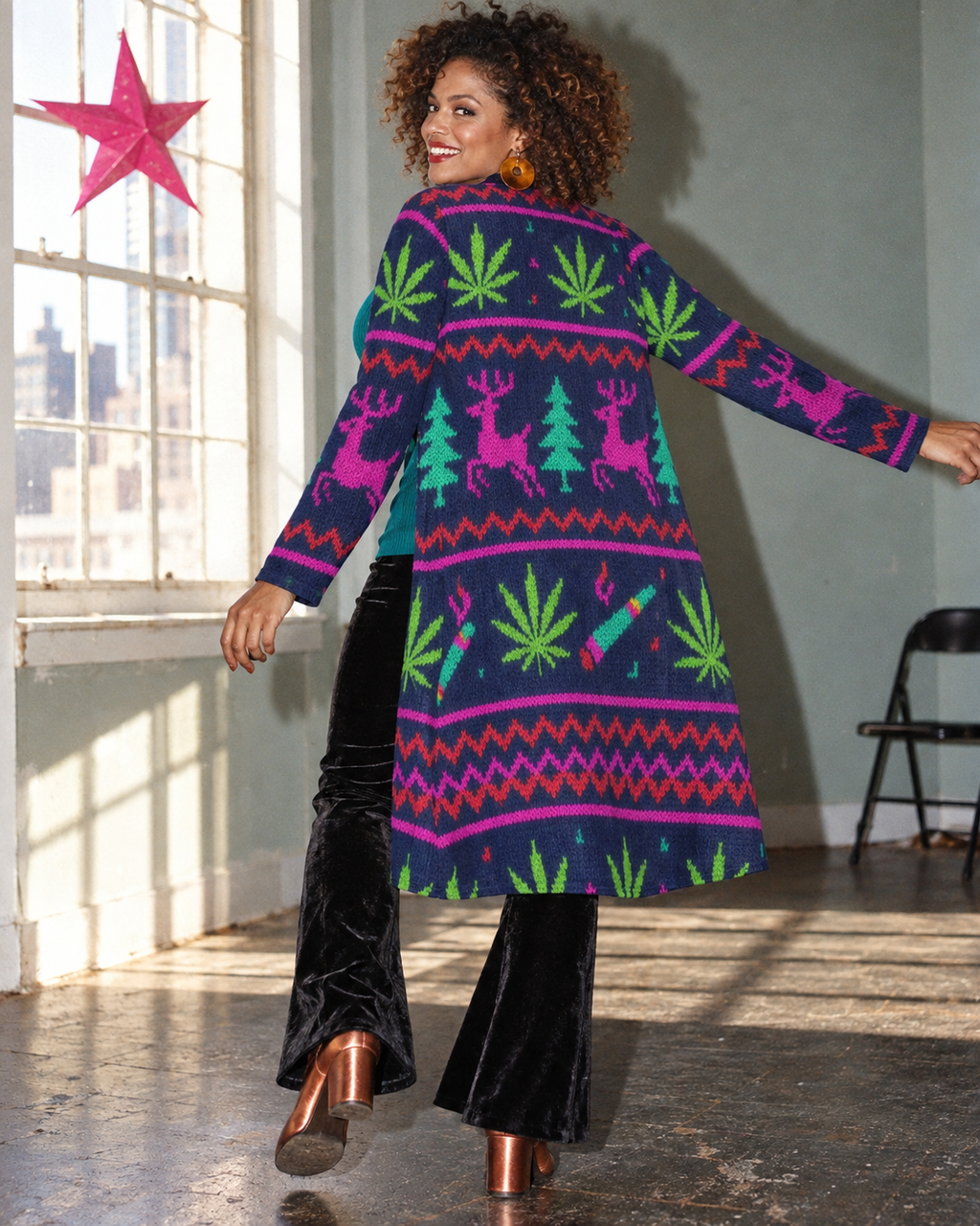 Back view of the Neon Xmas Mid-Length Cardigan in a flash-lit holiday editorial, showing pink reindeer, teal trees and Herb motifs.