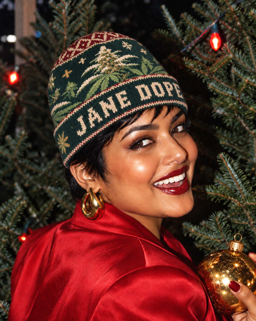 Nugs & Mistletoe beanie worn with a red satin blazer in a festive close-up portrait