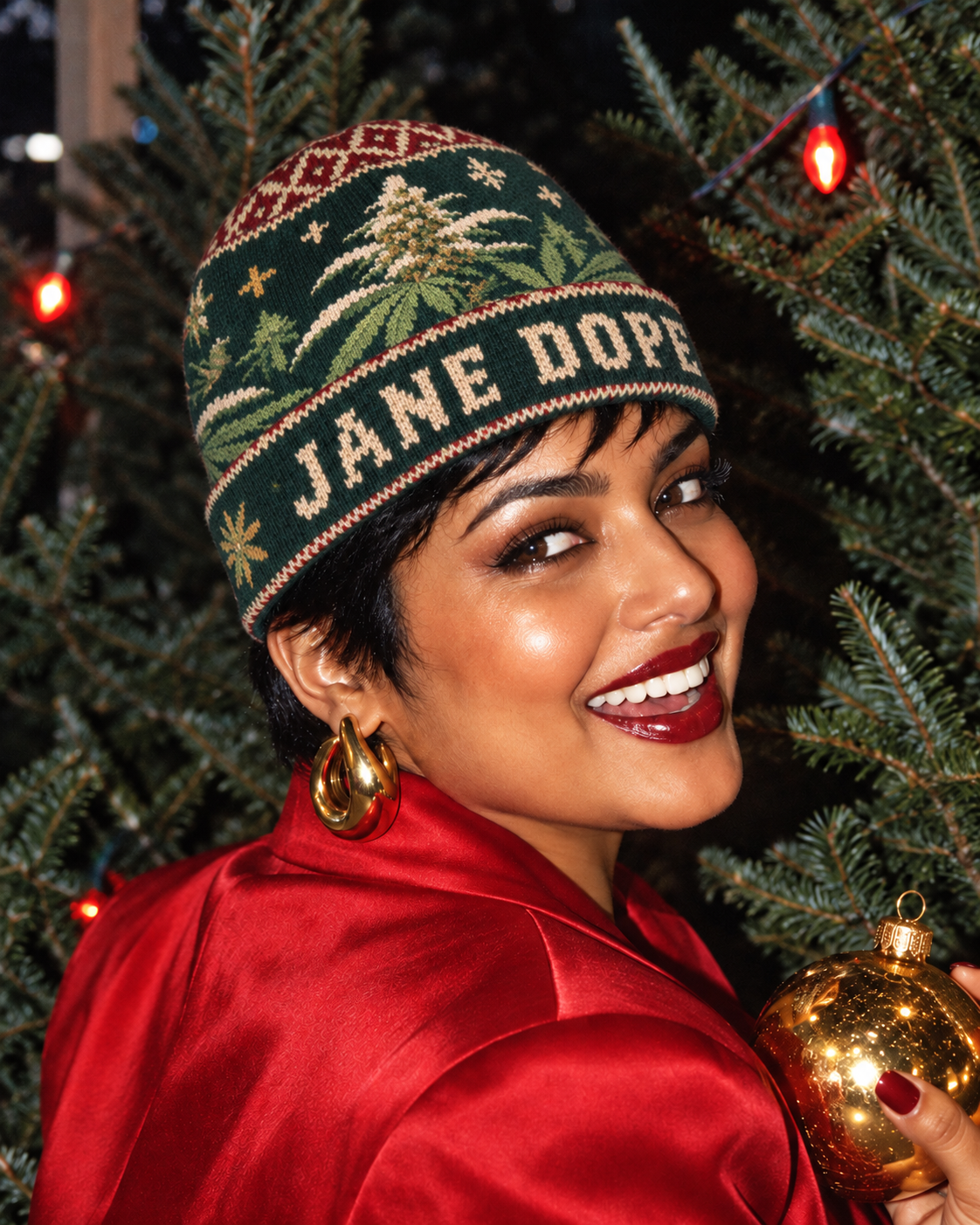 Nugs & Mistletoe beanie worn with a red satin blazer in a festive close-up portrait