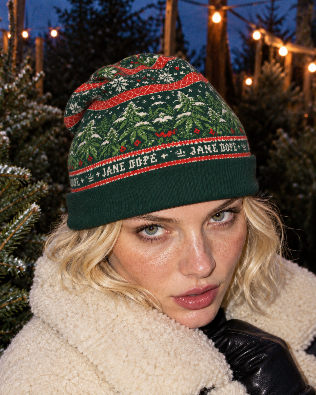 Nugs & Mistletoe Knit Beanie front view worn low on the forehead, showing the forest-green cuff and botanical jacquard