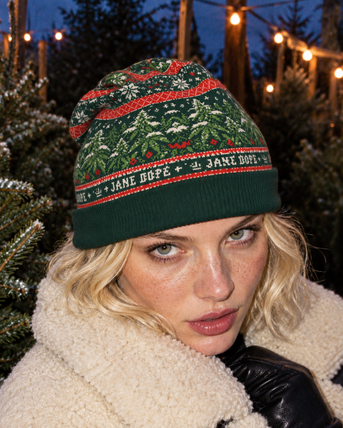 Nugs & Mistletoe Knit Beanie front view worn low on the forehead, showing the forest-green cuff and botanical jacquard