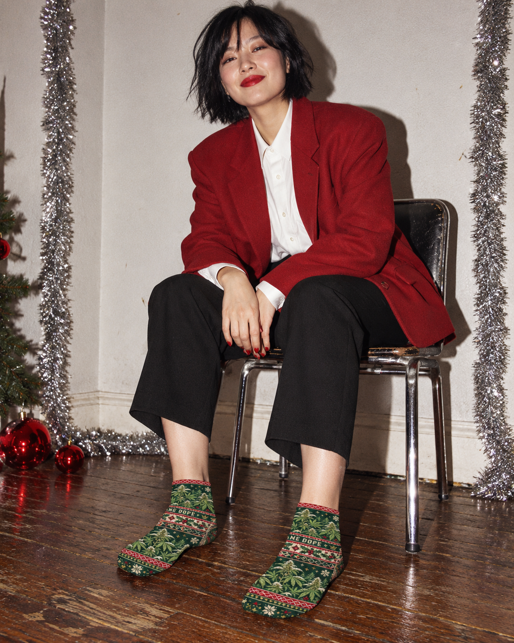 Green botanical Christmas ankle socks styled with cropped black trousers and a red blazer.