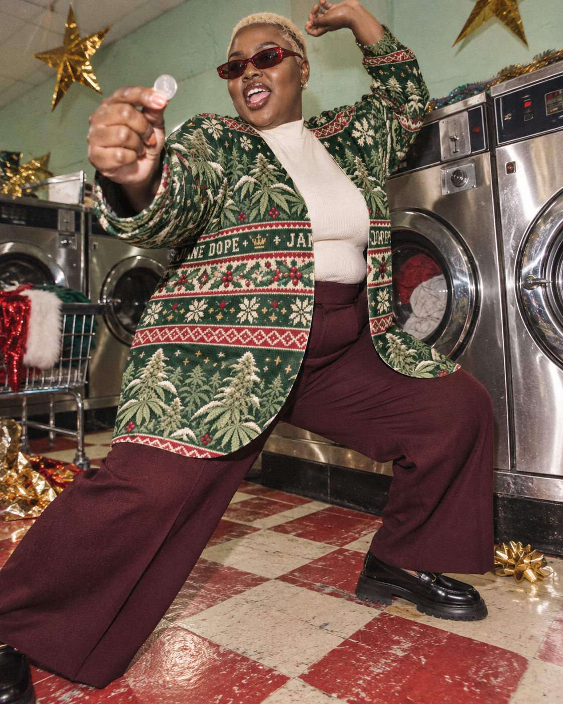 3XL variant: Nugs & Mistletoe cardigan with ivory top and burgundy trousers, striking a disco pose beside laundry machines