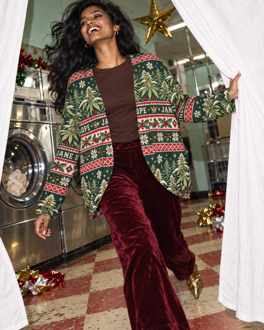 Nugs & Mistletoe cardigan styled with burgundy velvet trousers, stepping through sheets in a holiday laundrette