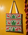 OG X-MAS Tote Bag front print and ivory shoulder straps on a yellow wall