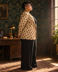 Standing side view of the Jane Dope Polka Buds Cazh Blazer with black wide-leg trousers against emerald Art Deco wallpaper.