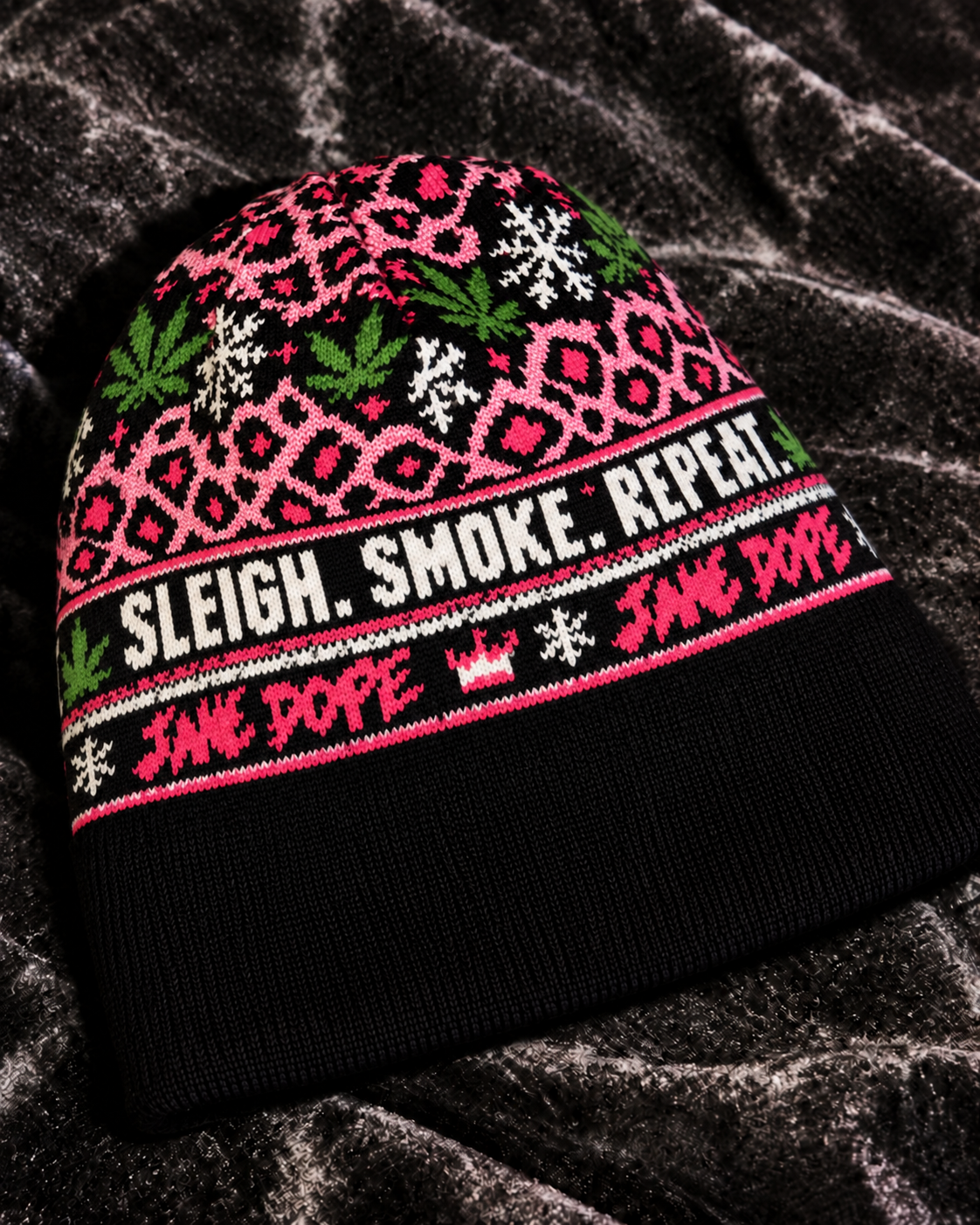 Close-up of the Primo Holiday beanie showing jacquard knit stitches and Sleigh Smoke Repeat lettering.