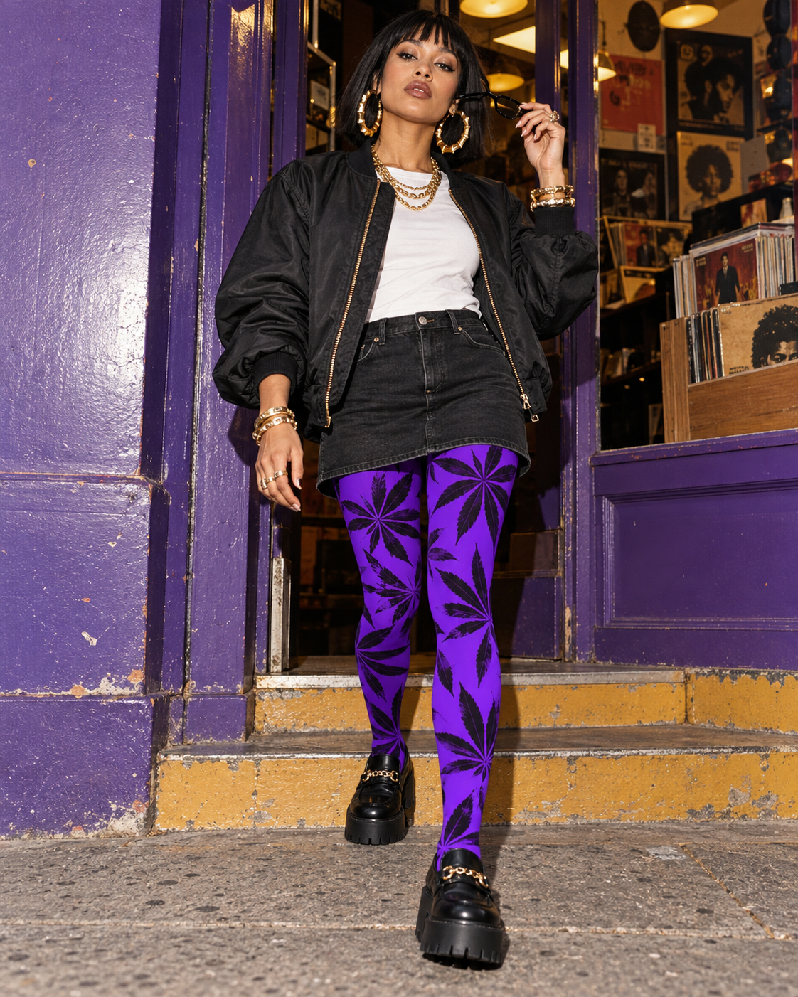Purple Runtz purple tights with black Herb leaves, styled with a black mini skirt and loafers in a walking pose.