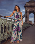 Roller Queen scarf-print wide-leg pants with a matching halter top, standing on a bridge at dusk.