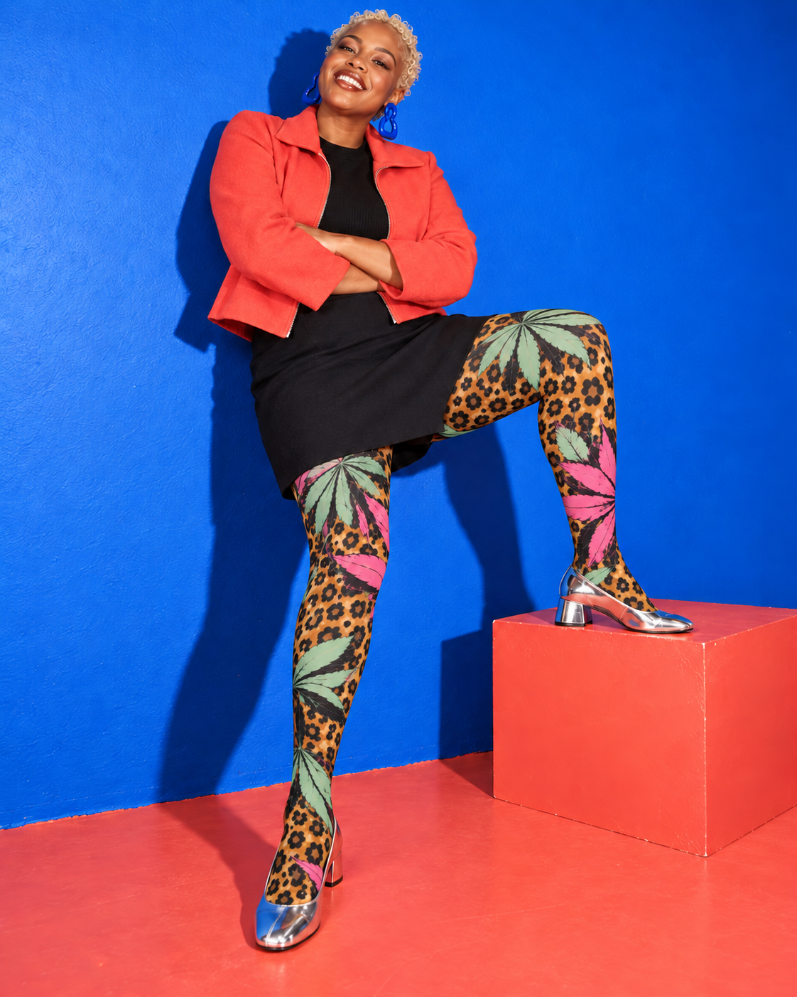 Runtz pink and mint botanical leopard tights, with one foot on a coral block and silver pumps. AI editorial illustration; styling accessories not included.