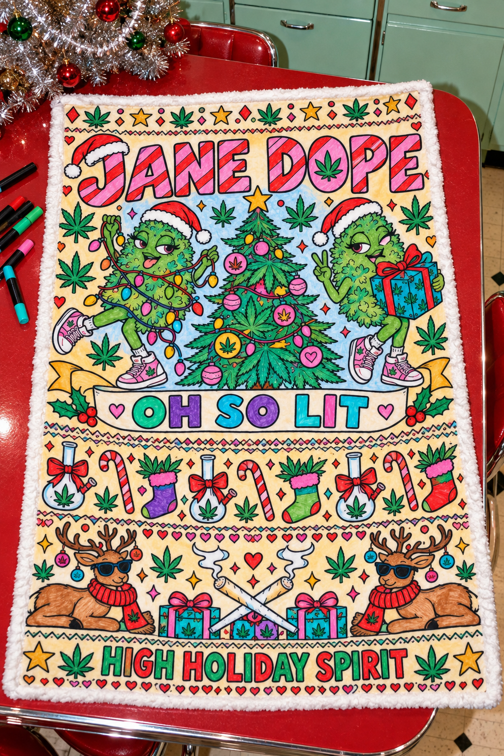 Fully coloured So Lit Xmas blanket inspiration with red lettering, green Nugs, colourful decorations and brown reindeer; blanket arrives uncoloured