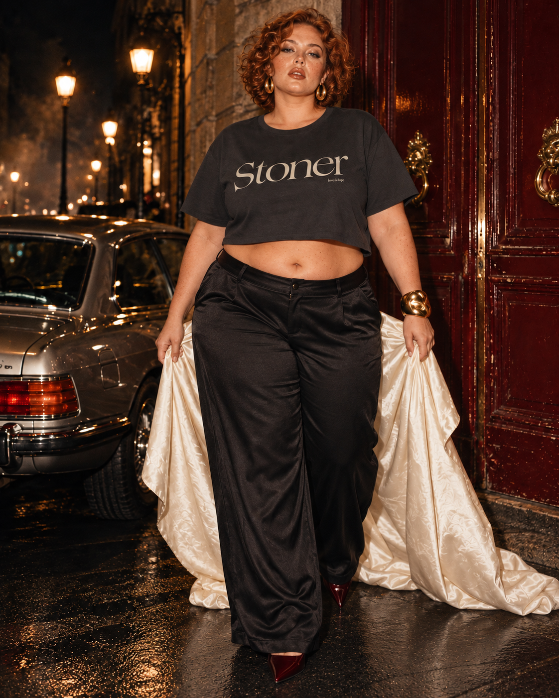 Stoner Diop charcoal crop tee on a plus-size model stepping forward in black satin trousers with an ivory stole.