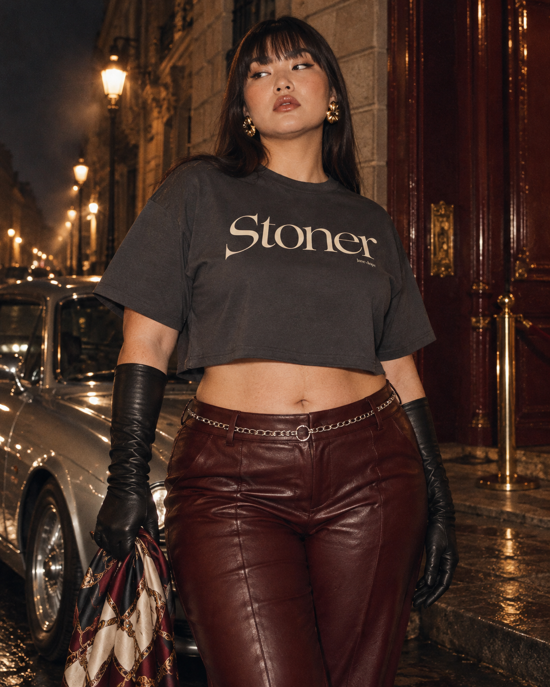 Front view of the short, boxy Stoner Diop tee on a fuller-bodied model in oxblood leather trousers.