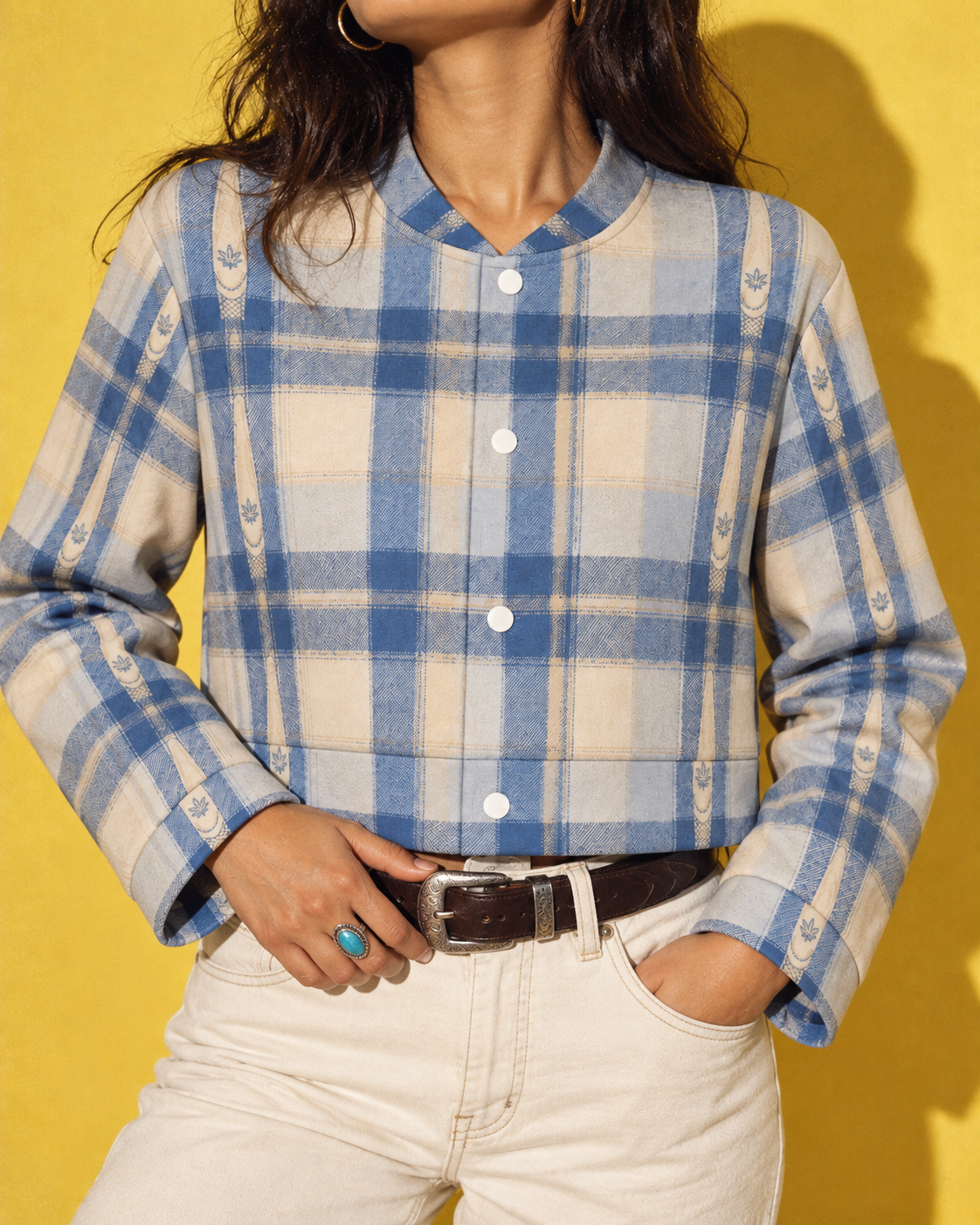 Close detail of Sunday Sesh blue-and-cream plaid, tiny leaf motifs, round neckline and four white front snaps.