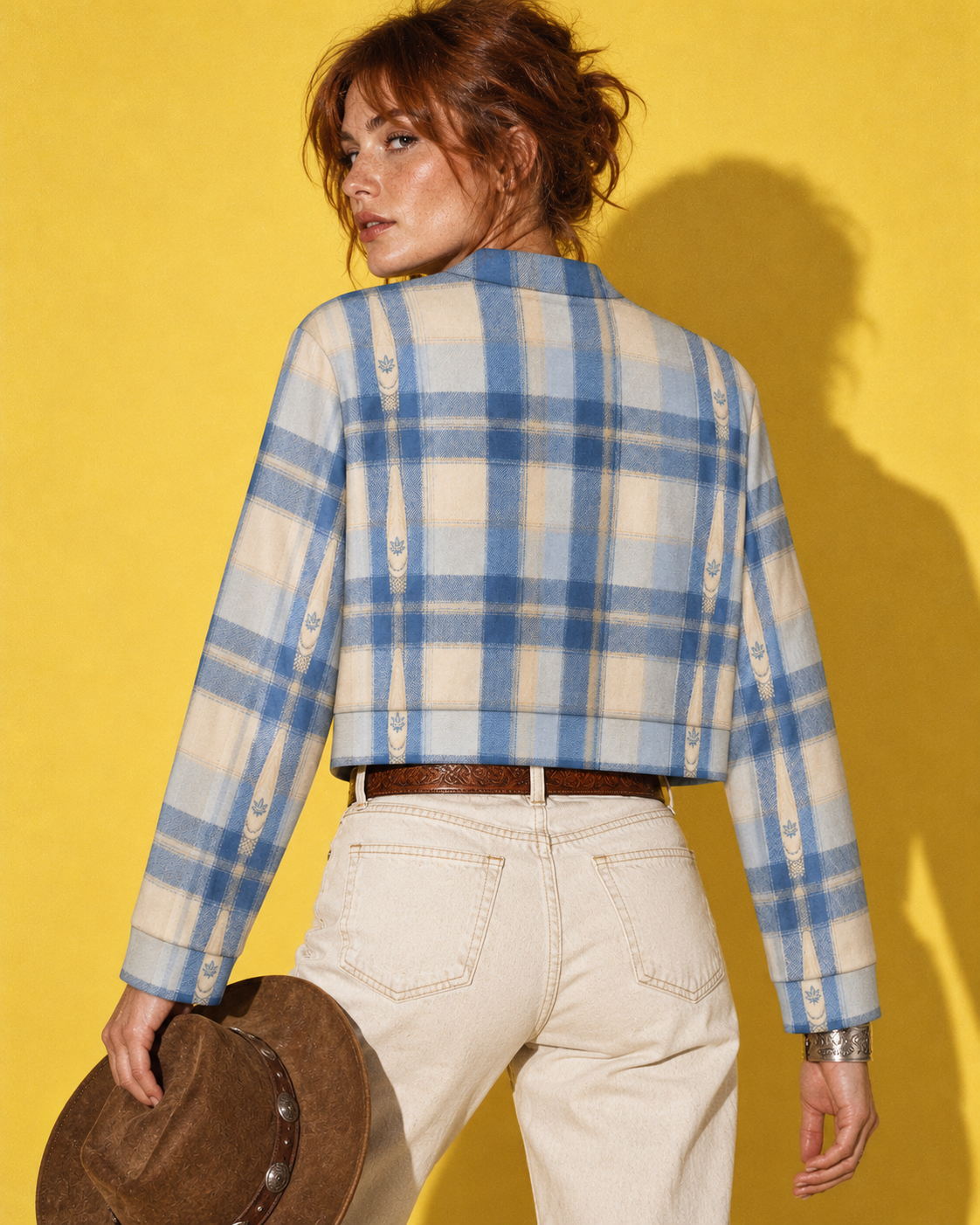 Back of the Sunday Sesh blue plaid cropped jacket with cream leaf-motif stripes, styled with ecru denim on yellow.