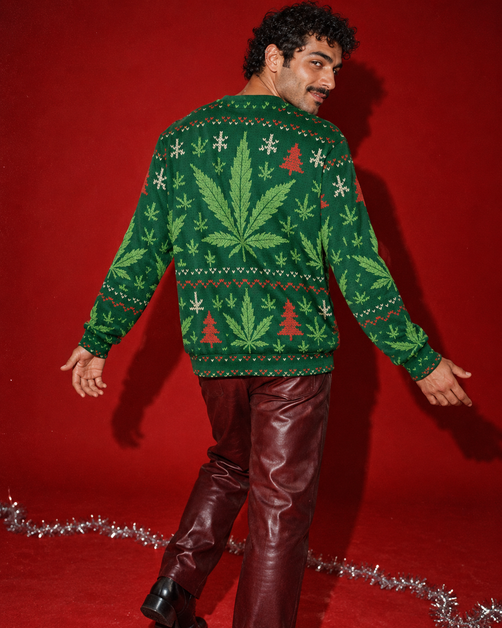 Back of the XMAS Fugly Sweatershirt on a model turning in a deep red studio, showing the central Herb leaf and holiday pattern.